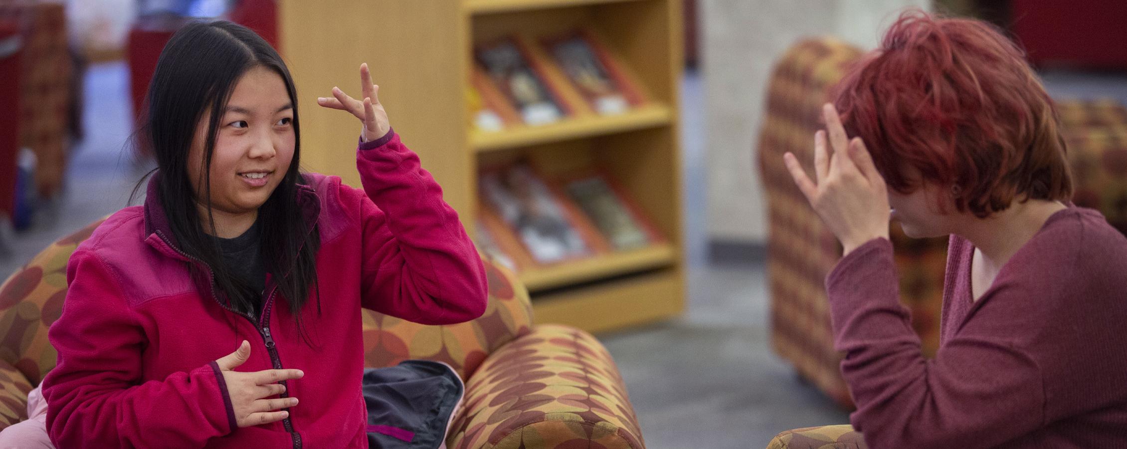 A person tutors another person in sign language.