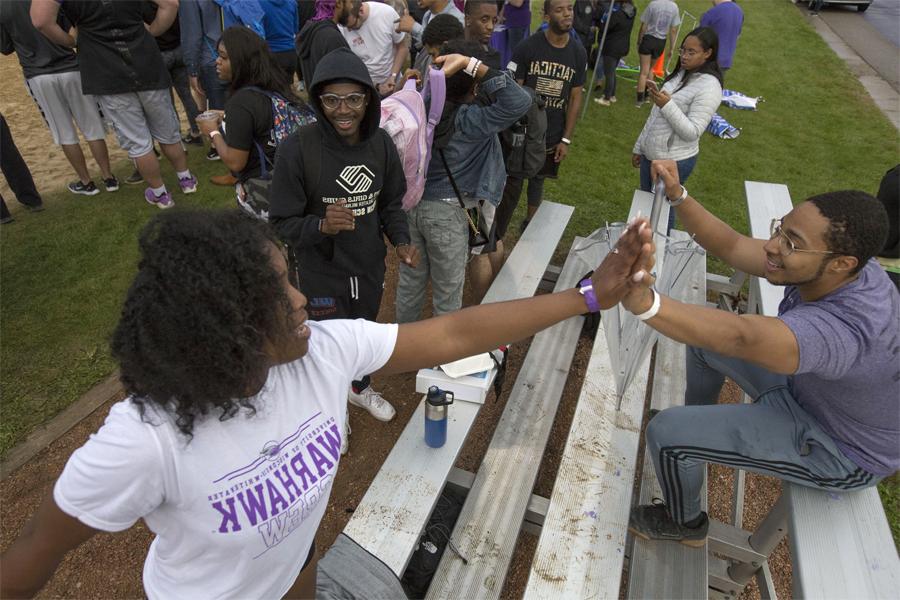 Two students high five.