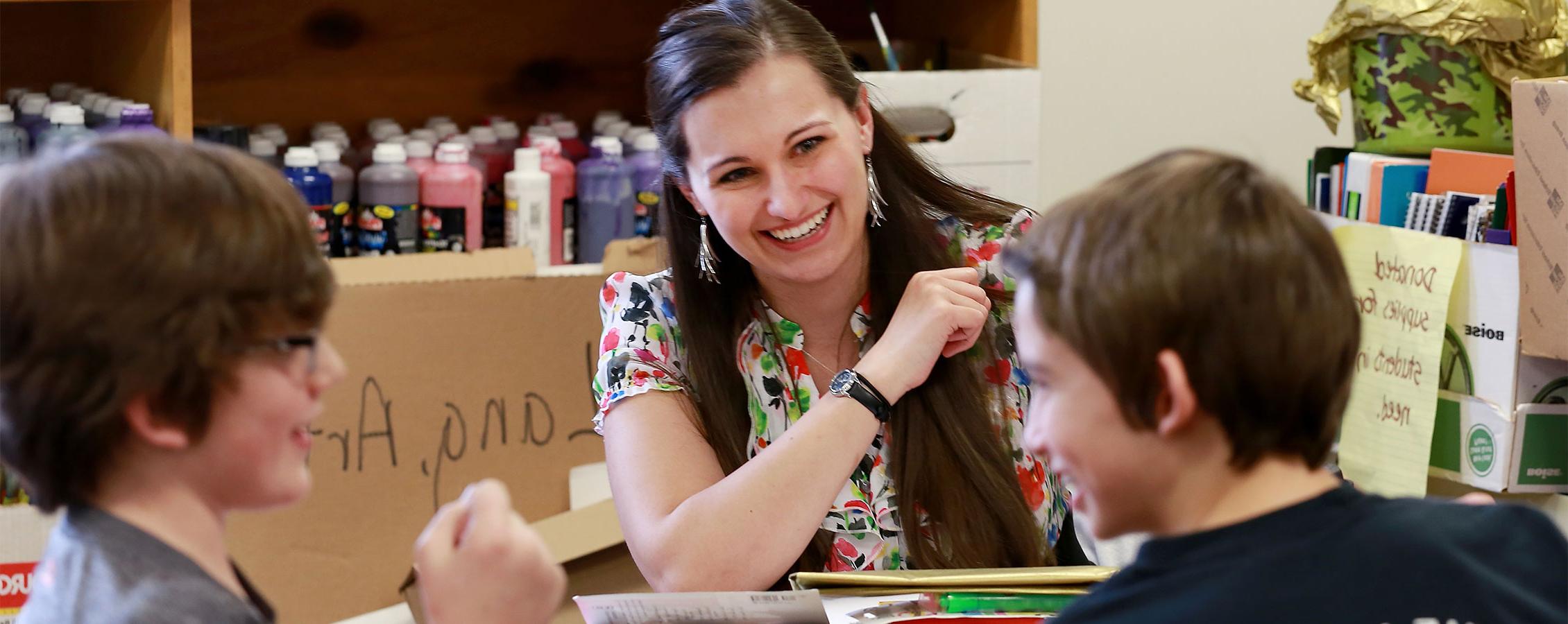 Elementary school teacher laughs with students