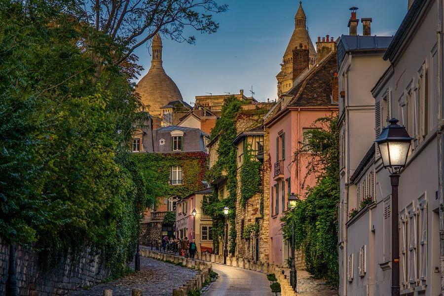 Streets of a European city with vines growing on the buildings.